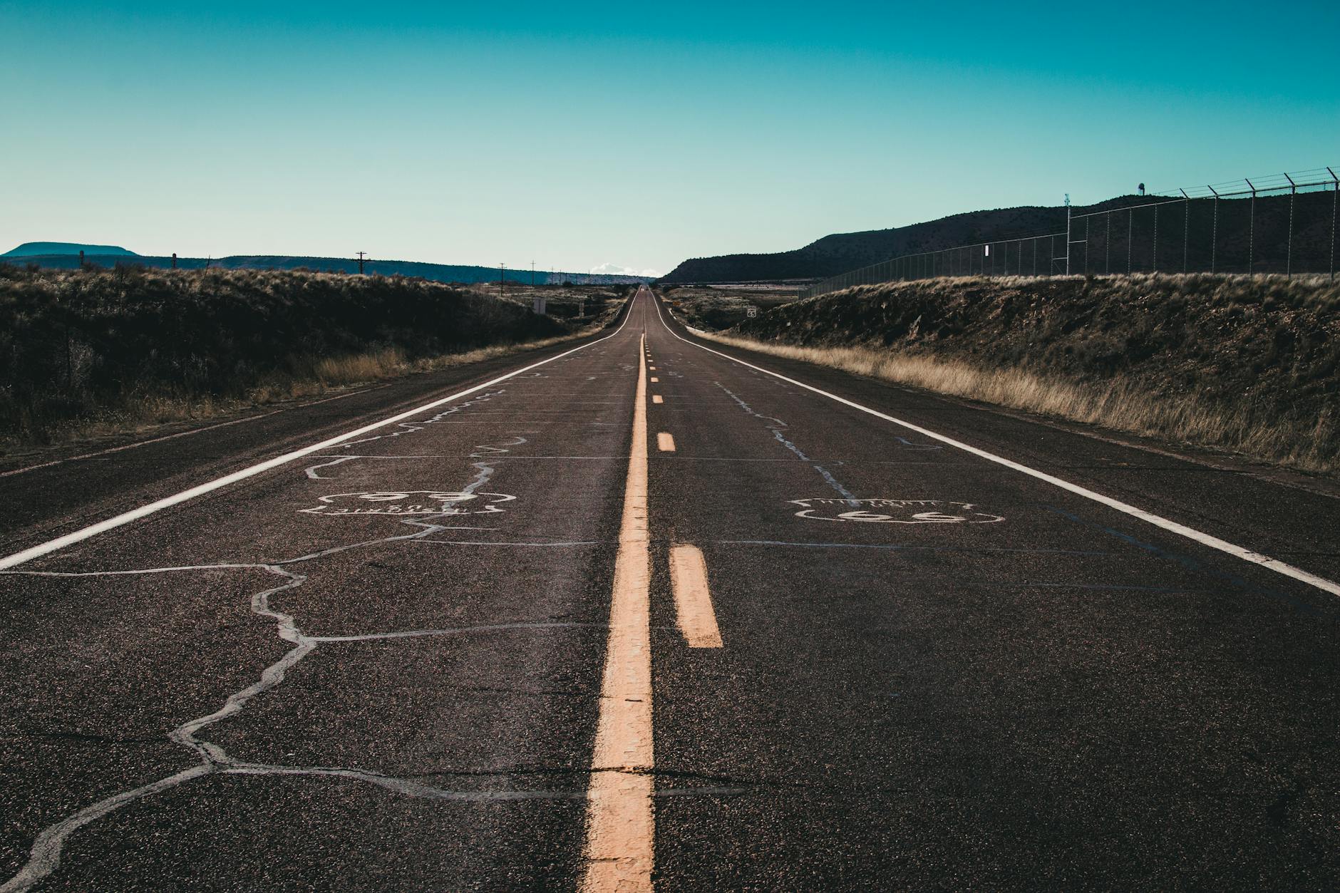 long and empty road under blue sky
